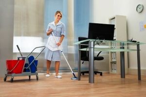 39653541 - young happy female maid cleaning floor in office